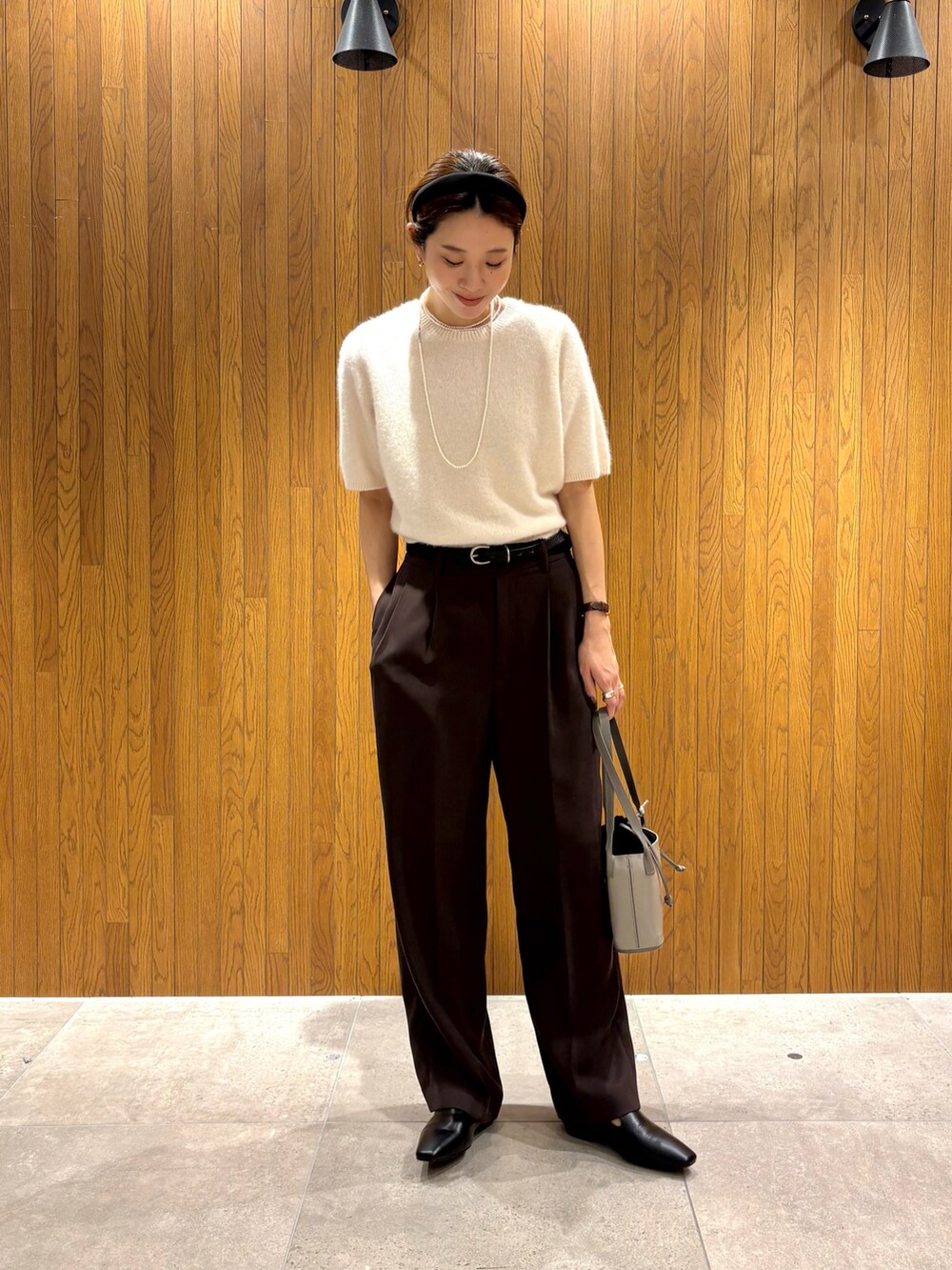 ホワイト系のニット/セーター、ブラウン系のその他パンツ、グレー系のハンドバッグを着用したレディースの秋コーディネートの5枚目の写真