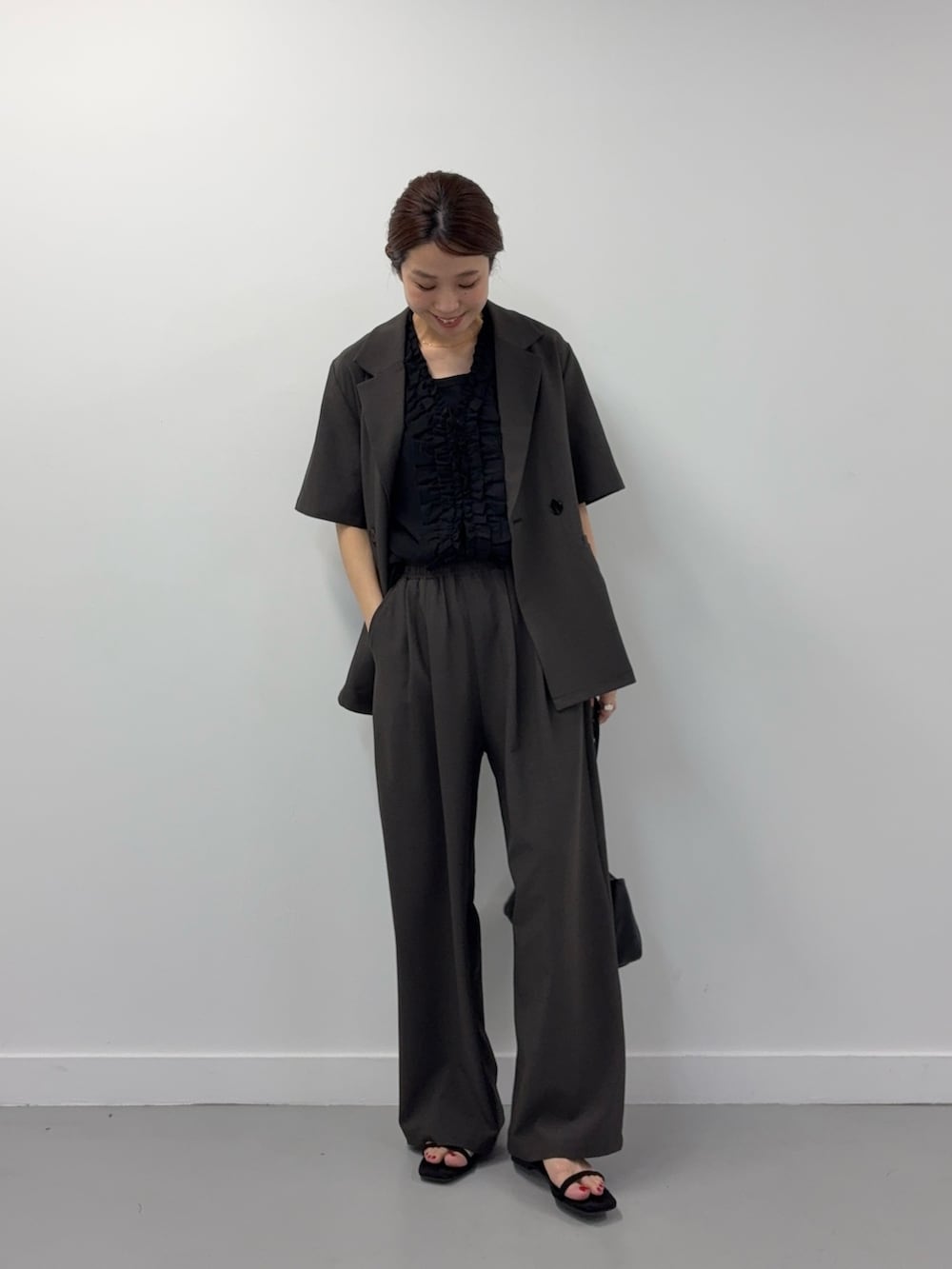 ブラック系のシャツ/ブラウス、ブラック系のショルダーバッグ、ブラック系のサンダルを着用したレディースの春コーディネートの4枚目の写真