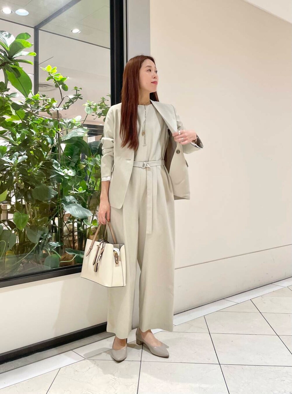 ホワイト系のトートバッグ、ベージュ系のパンプス、ホワイト系のシャツ/ブラウスを着用したレディースの冬コーディネートの2枚目の写真