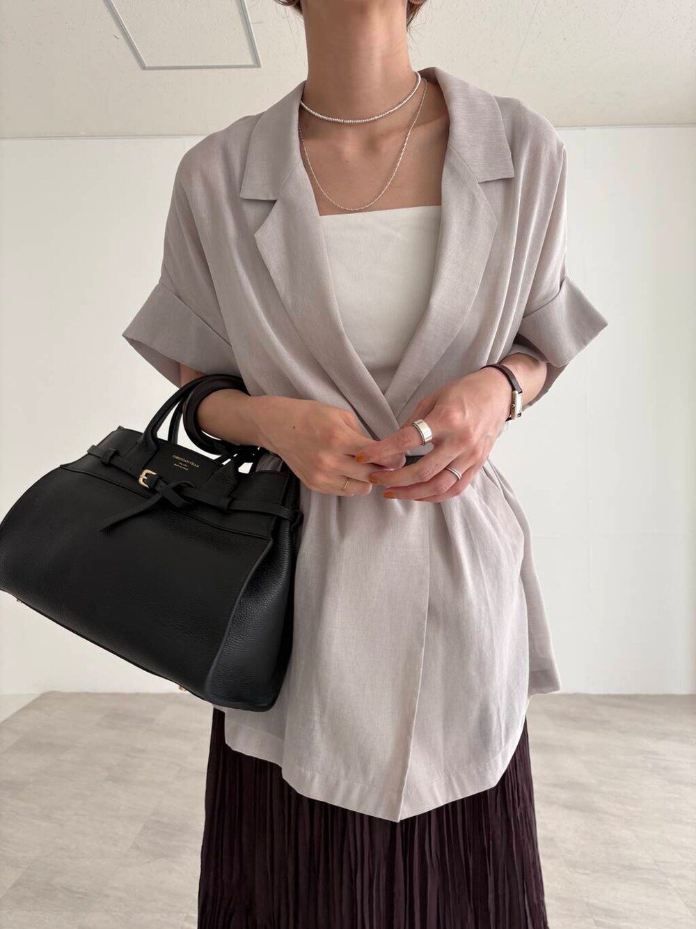 ホワイト系のキャミソール、ブラウン系のスカート、ブラック系のサンダルを着用したレディースの夏コーディネートの7枚目の写真