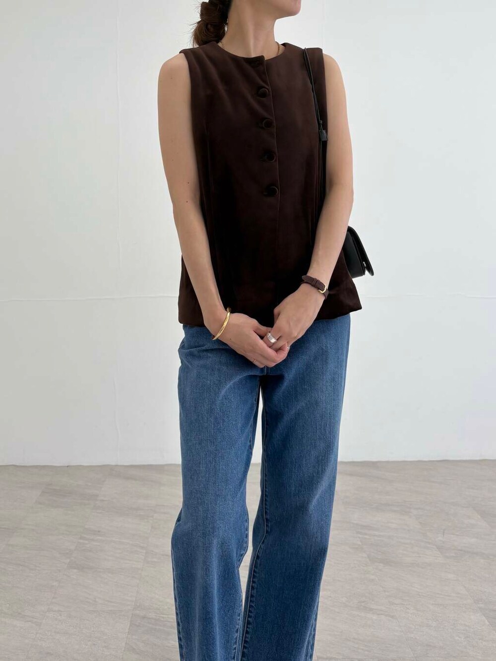 ブラック系のショルダーバッグ、ブラック系のパンプス、ブルー系のデニムパンツを着用したレディースの夏コーディネートの7枚目の写真