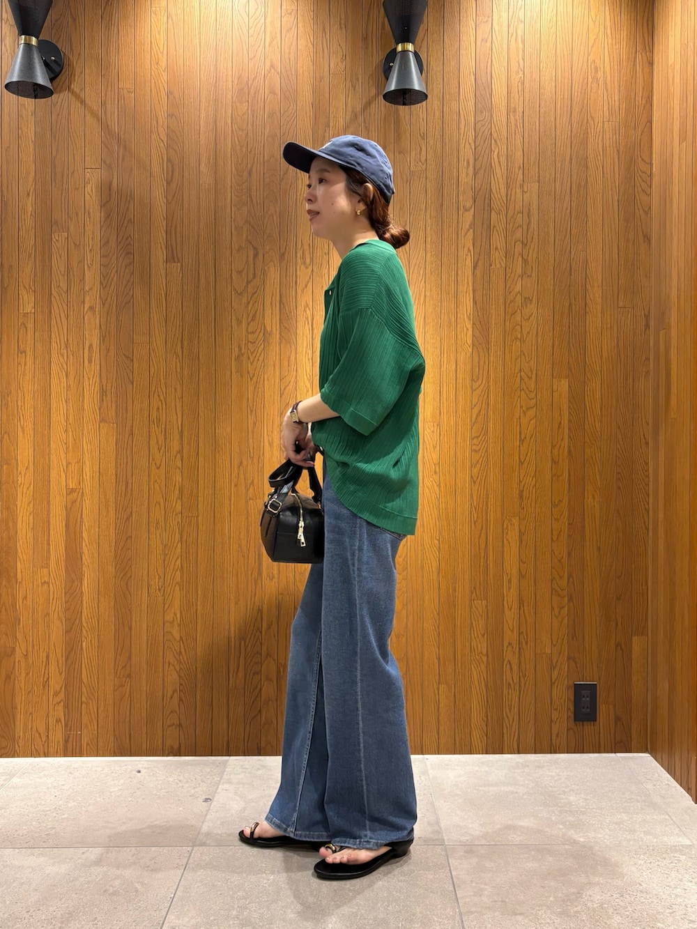 ホワイト系のTシャツ/カットソー、ブルー系のデニムパンツ、ブラック系のハンドバッグを着用したレディースの夏コーディネートの2枚目の写真
