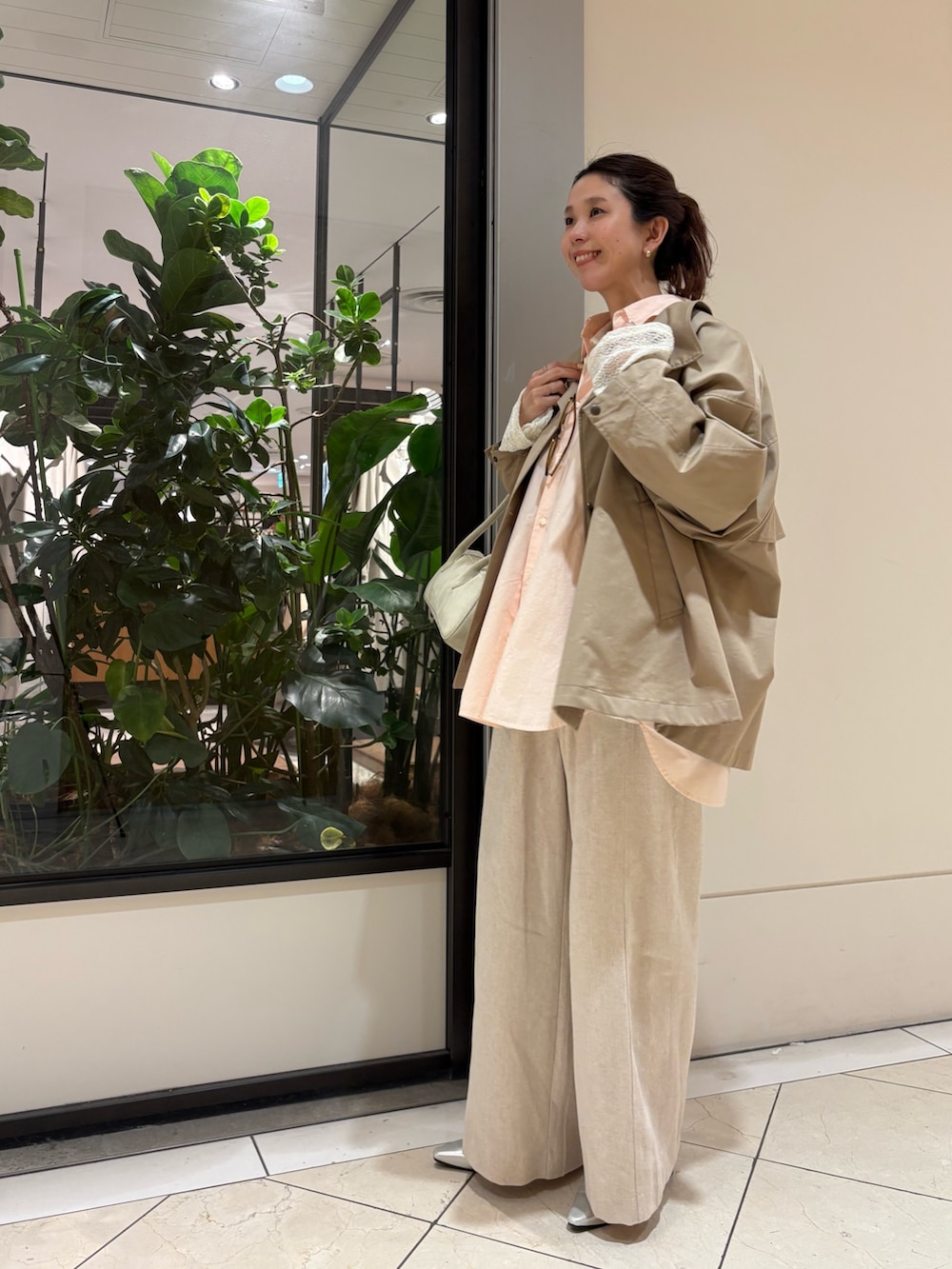 ベージュ系のトレンチコート、ブルー系のシャツ/ブラウス、ホワイト系のシャツ/ブラウスを着用したレディースの冬コーディネートの2枚目の写真