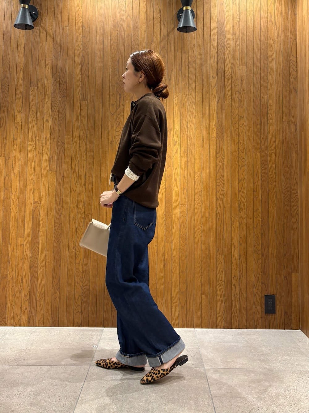 ブラウン系のニット/セーター、ホワイト系のTシャツ/カットソー、ブルー系のデニムパンツを着用したレディースの秋コーディネートの2枚目の写真