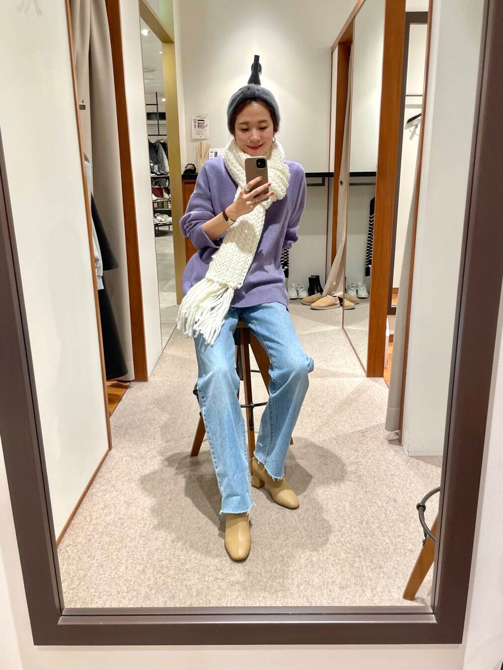 ブルー系のデニムパンツ、ベージュ系のブーツ、パープル系のニット/セーターを着用したレディースの冬コーディネートの3枚目の写真