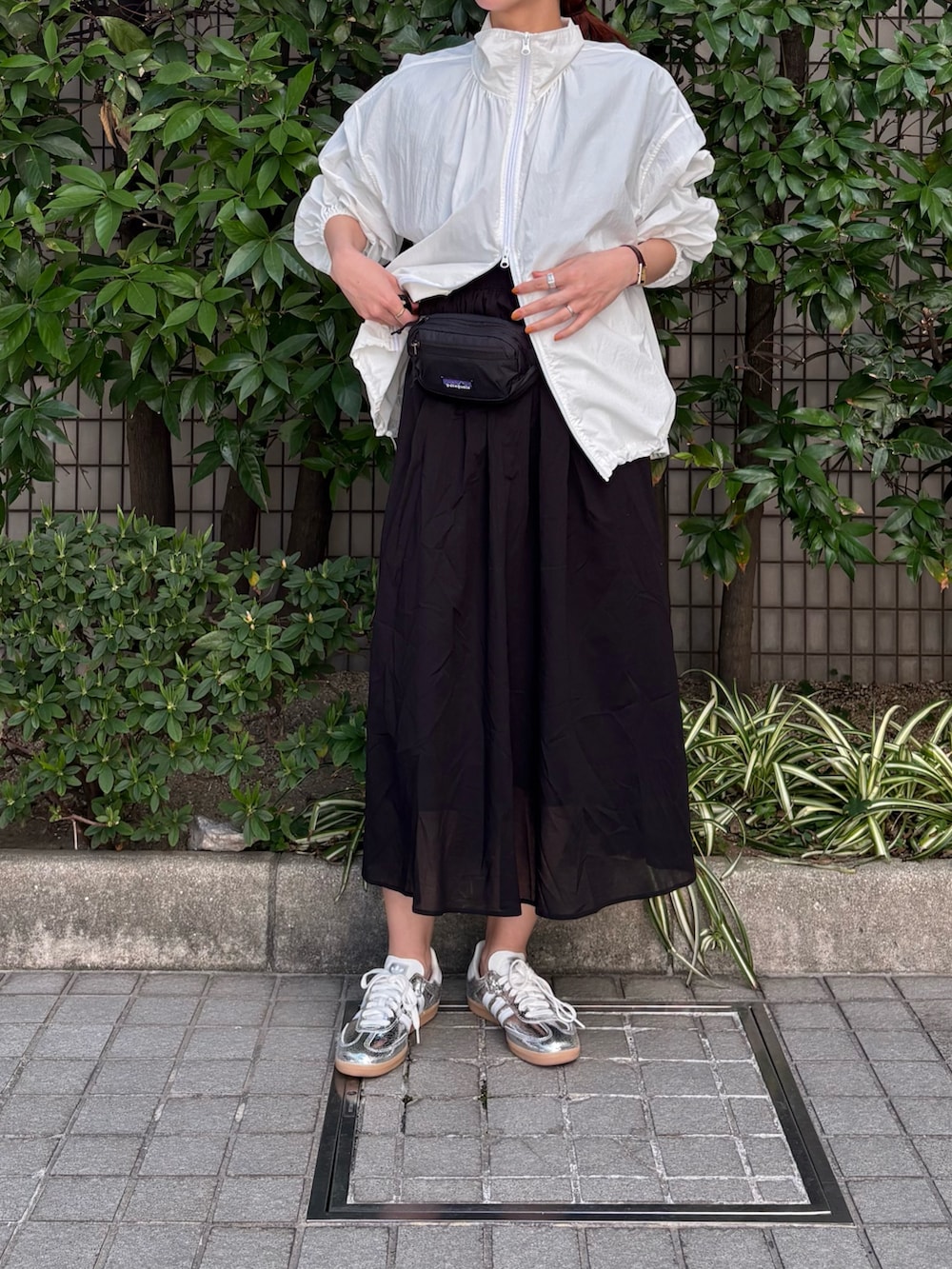 ホワイト系のブルゾン、ブラック系のワンピース、ブラック系のボディバッグ/ウエストポーチを着用したレディースの春コーディネートの2枚目の写真