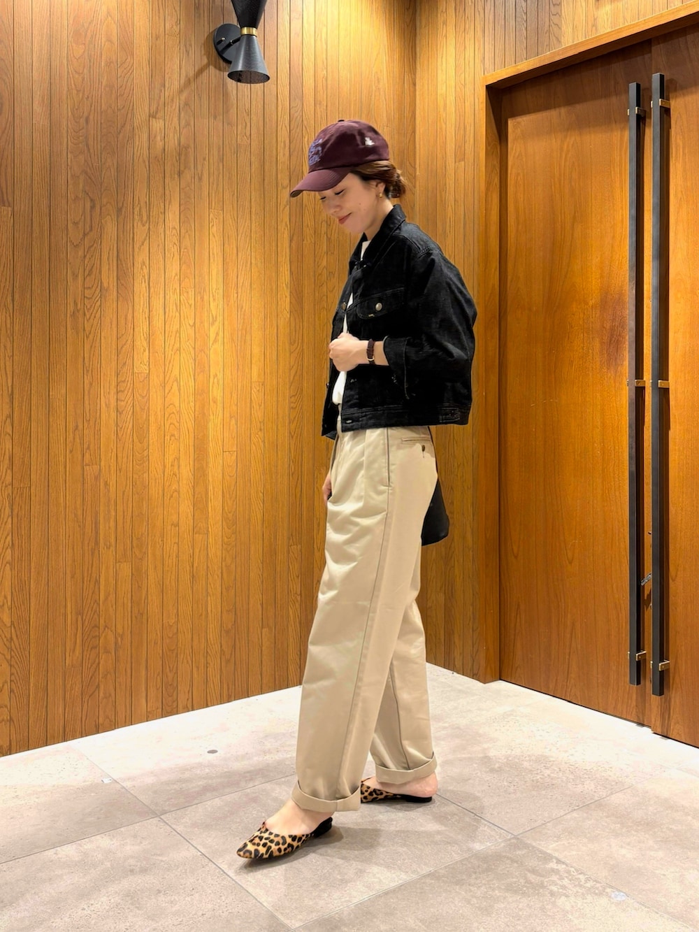 ホワイト系のTシャツ/カットソー、ベージュ系のチノパンツ、ブラック系のショルダーバッグを着用したレディースの秋コーディネートの2枚目の写真