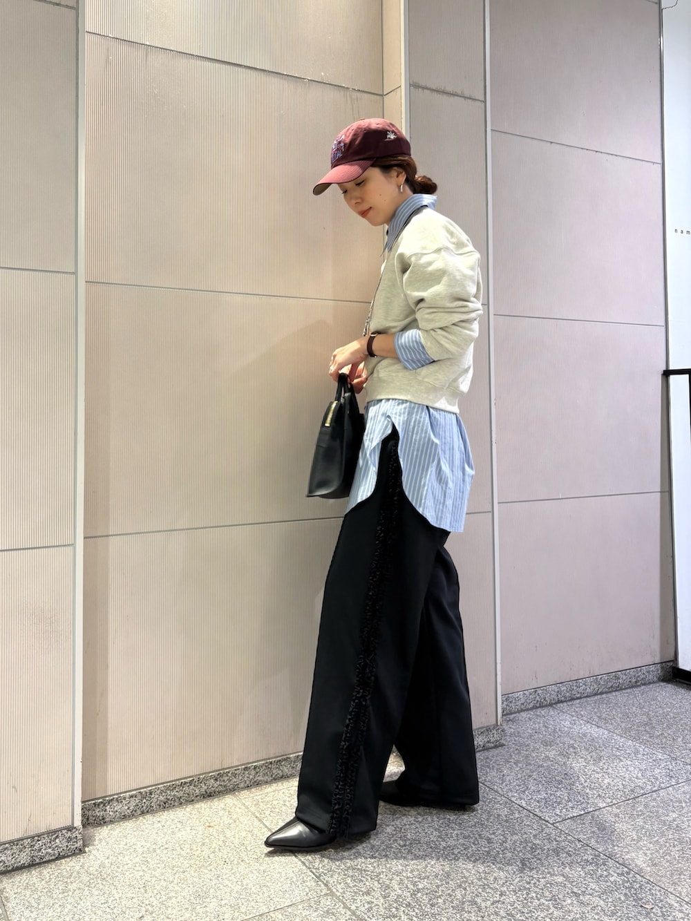 ベージュ系のスウェット、ブラック系のブーツ、ブラック系のショルダーバッグを着用したレディースの冬コーディネートの2枚目の写真