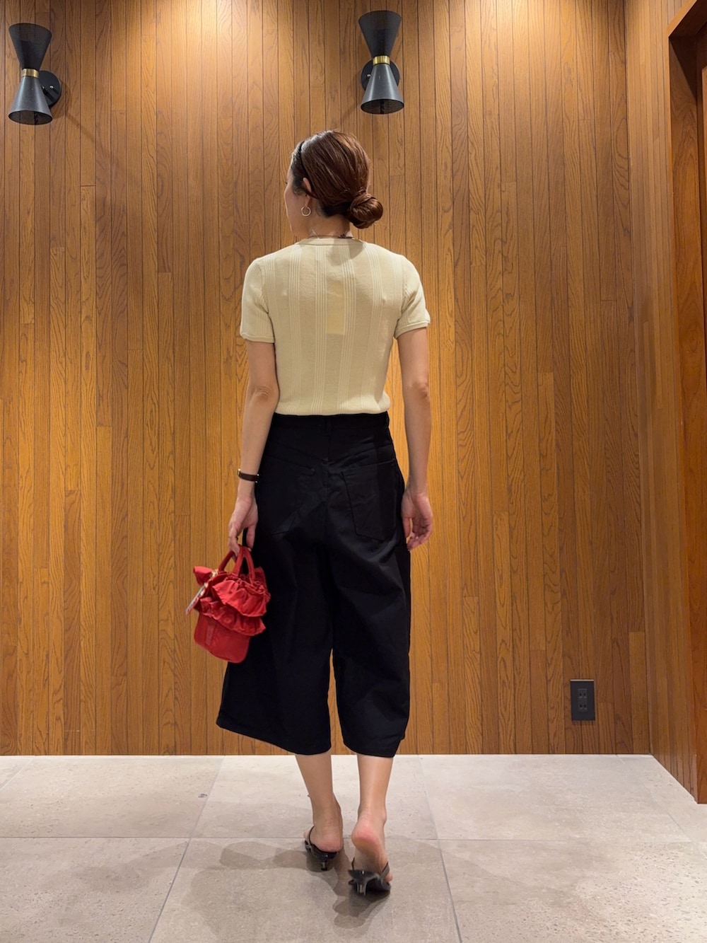 ホワイト系のニット/セーター、ブラック系のその他パンツ、ブラック系のサンダルを着用したレディースの夏コーディネートの3枚目の写真