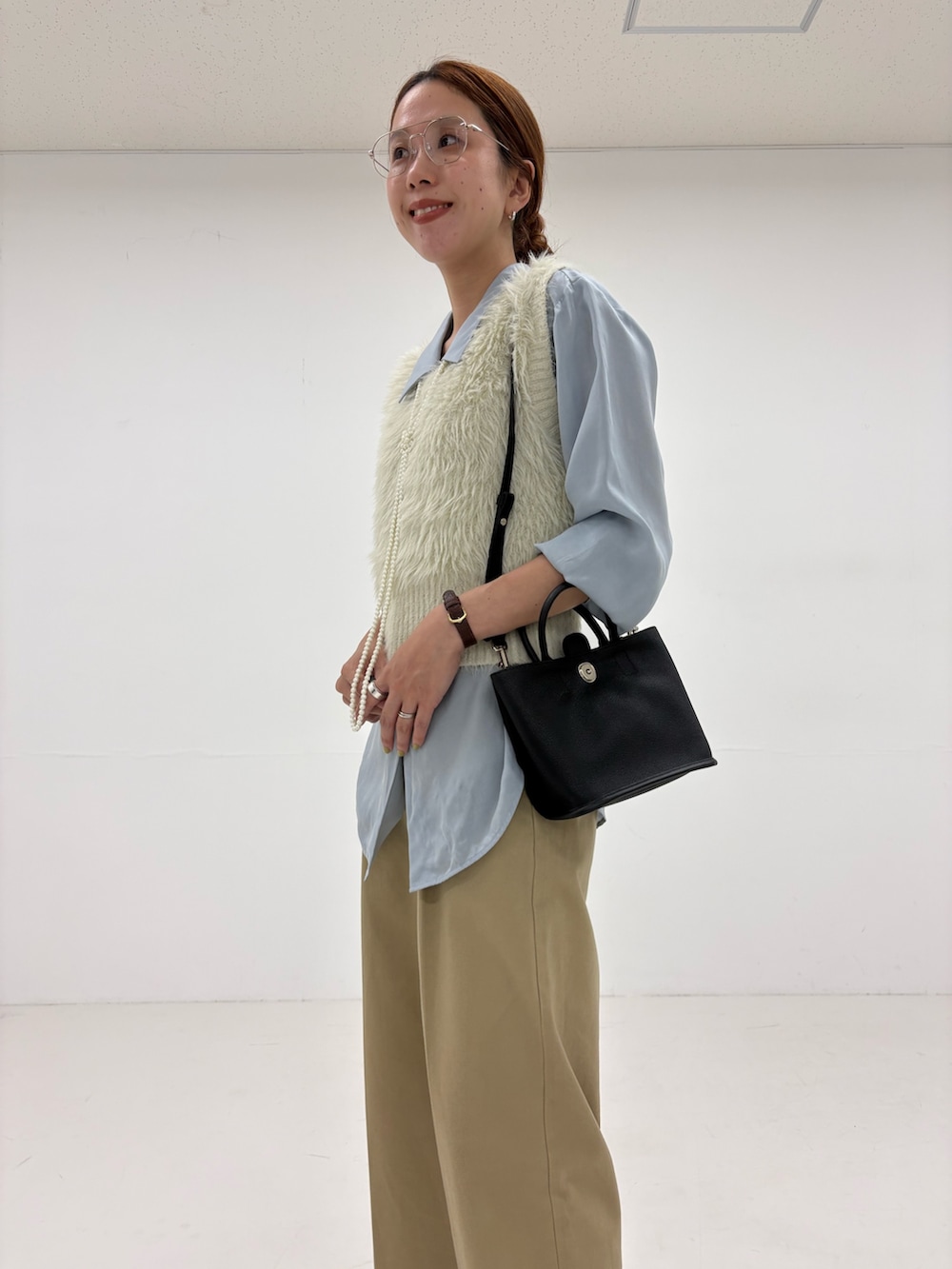 ホワイト系のベスト、ベージュ系のその他パンツ、ブルー系のシャツ/ブラウスを着用したレディースの秋コーディネートの7枚目の写真