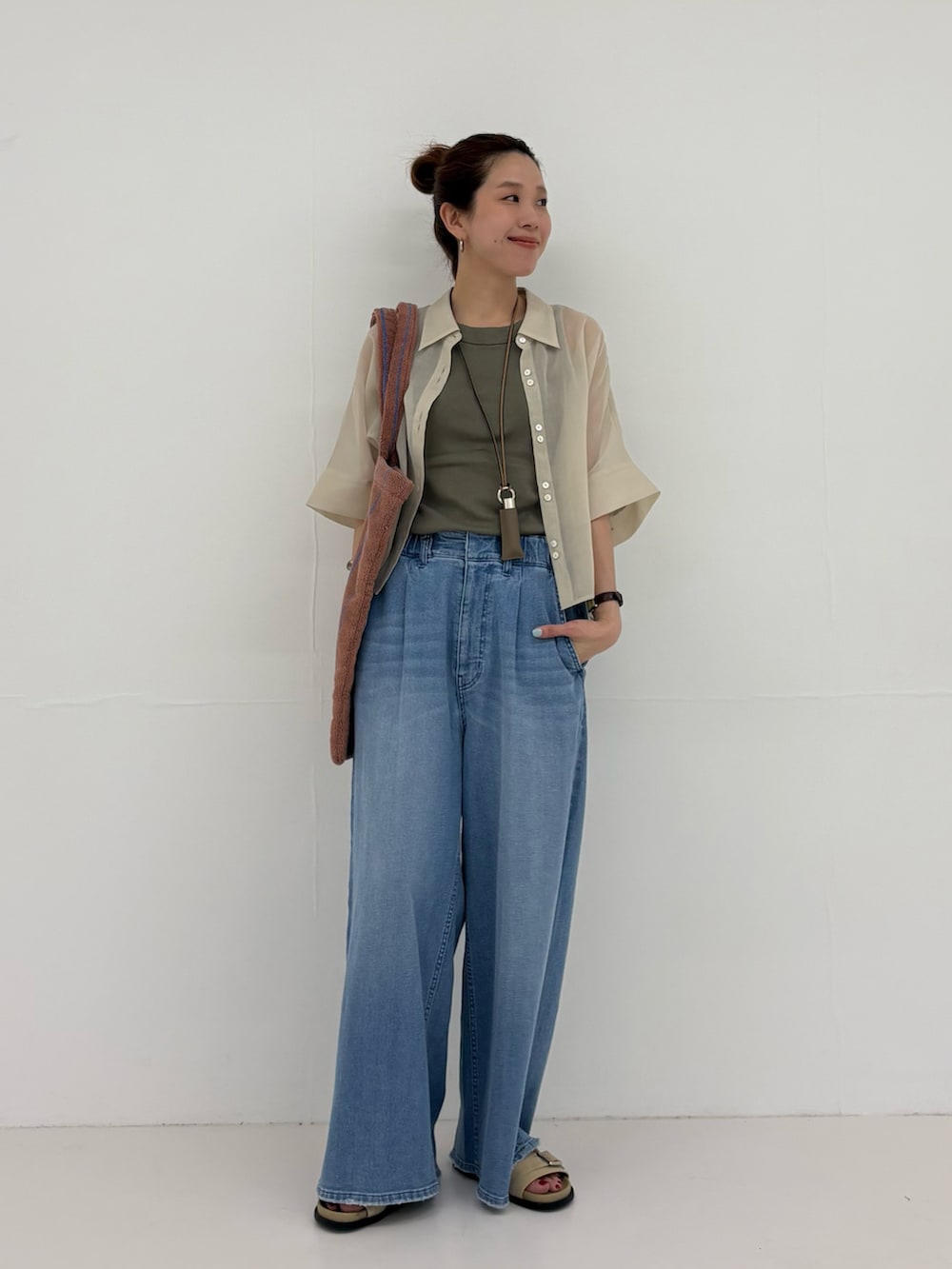 グレー系のシャツ/ブラウス、ブルー系のデニムパンツ、イエロー系のトートバッグを着用したレディースの春コーディネートの4枚目の写真