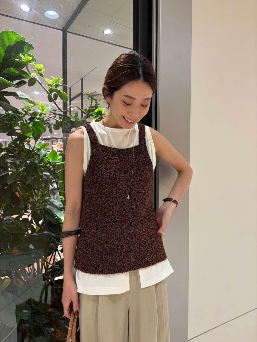 ブラウン系のキャミソール、ベージュ系のその他パンツ、ホワイト系のタンクトップを着用したレディースの夏コーディネートの7枚目の写真