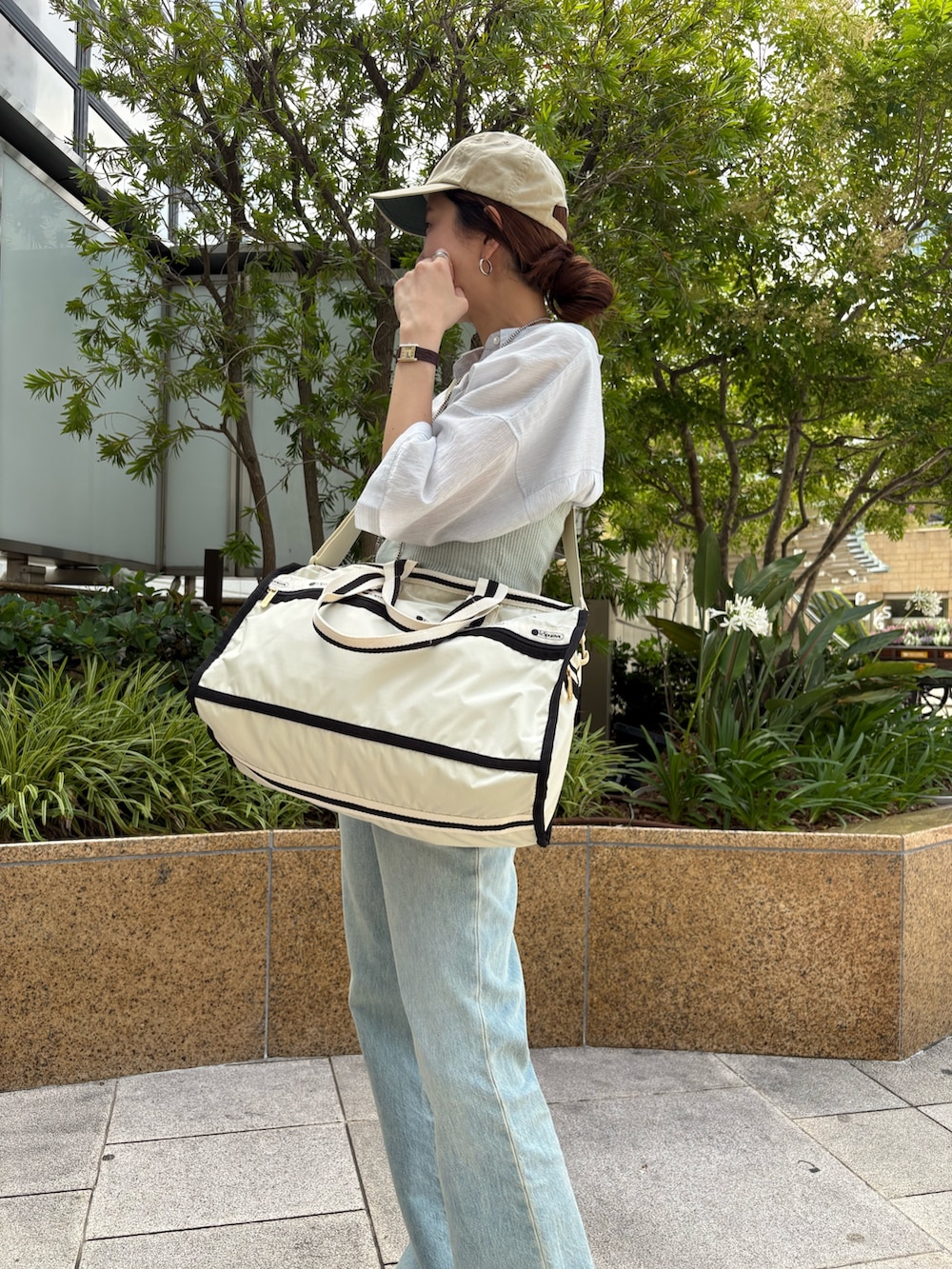 ブルー系のシャツ/ブラウス、ベージュ系のショルダーバッグ、ブルー系のデニムパンツを着用したレディースの夏コーディネートの8枚目の写真