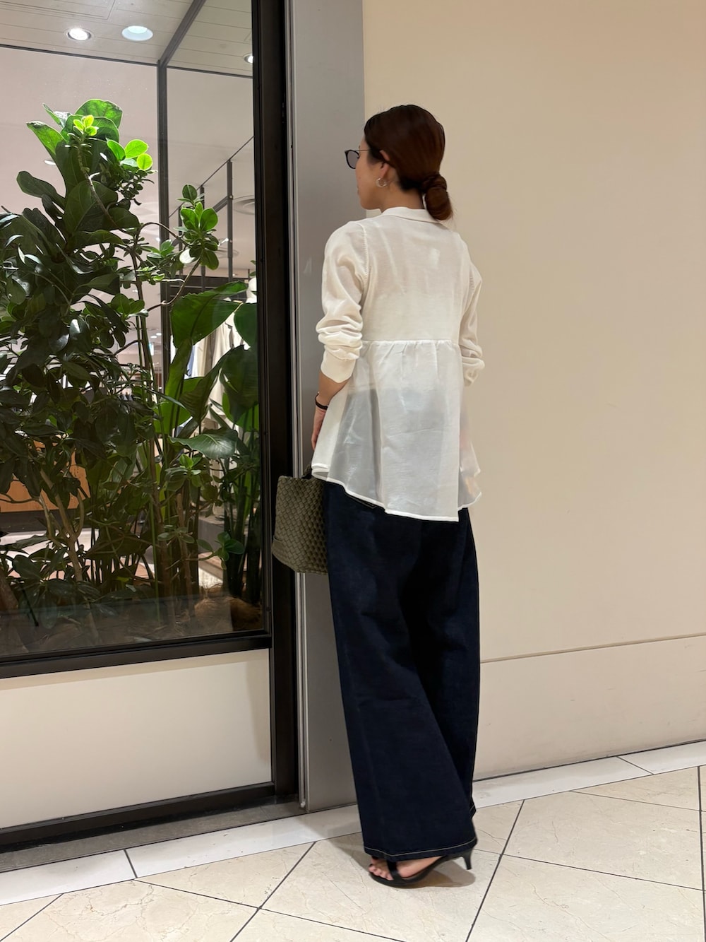 ホワイト系のカーディガン/ボレロ、ブルー系のデニムパンツ、グリーン系のトートバッグを着用したレディースの春コーディネートの3枚目の写真