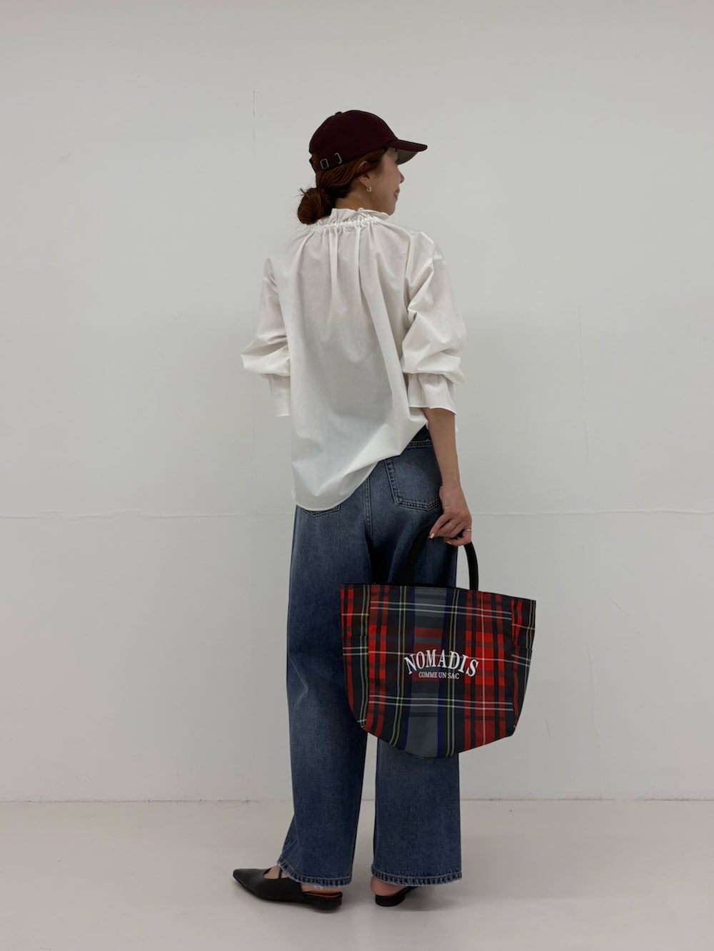 グレー系のトートバッグ、ブラック系のパンプス、ブルー系のデニムパンツを着用したレディースの夏コーディネートの3枚目の写真