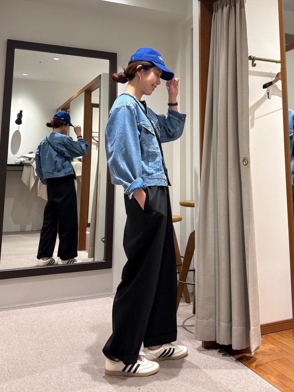 ブルー系のデニムジャケット、ブラック系のその他パンツ、ホワイト系のスニーカーを着用したレディースの冬コーディネートの2枚目の写真