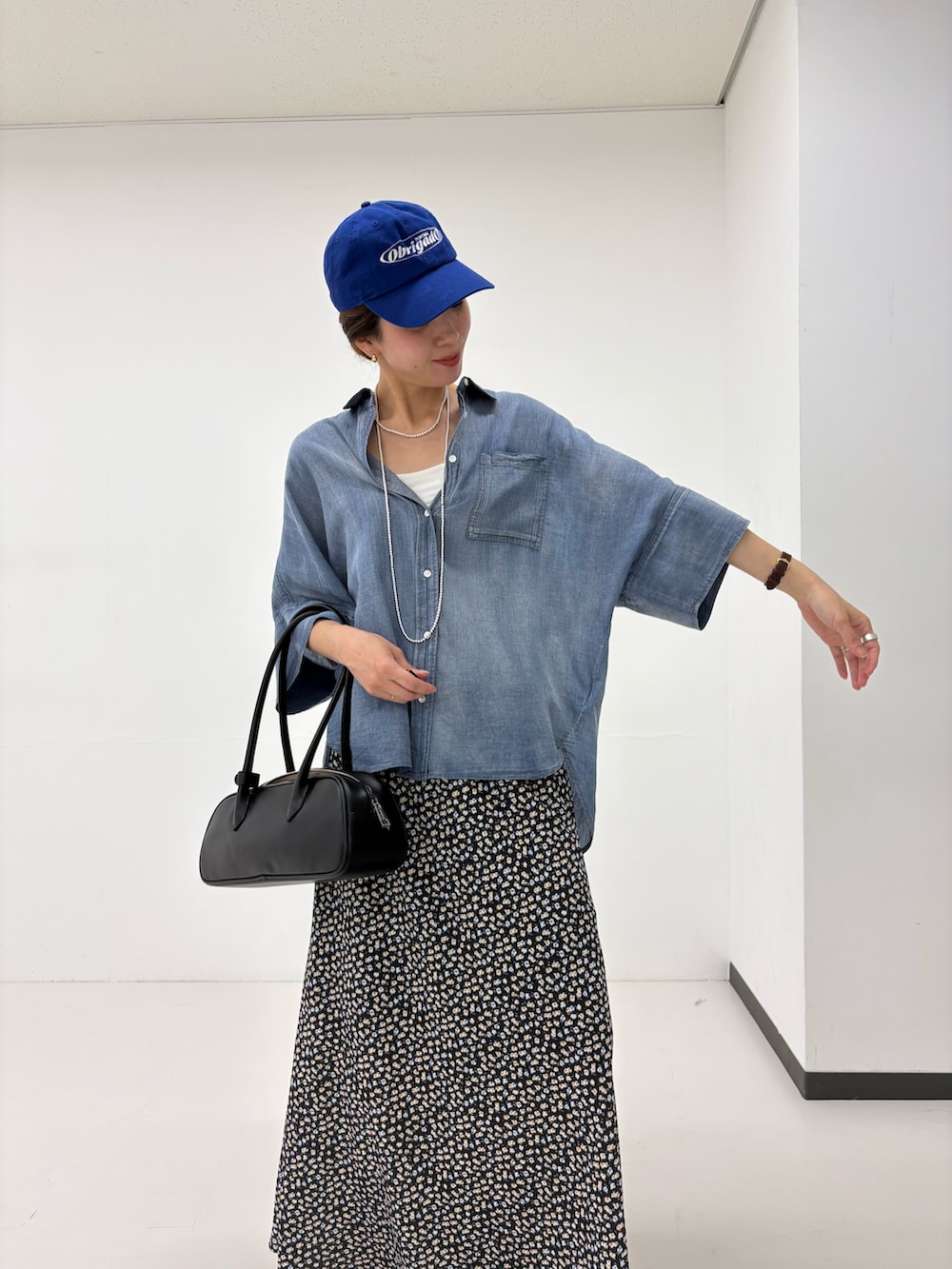 ホワイト系のスカート、ブルー系のシャツ/ブラウス、ブラック系のショルダーバッグを着用したレディースの夏コーディネートの6枚目の写真