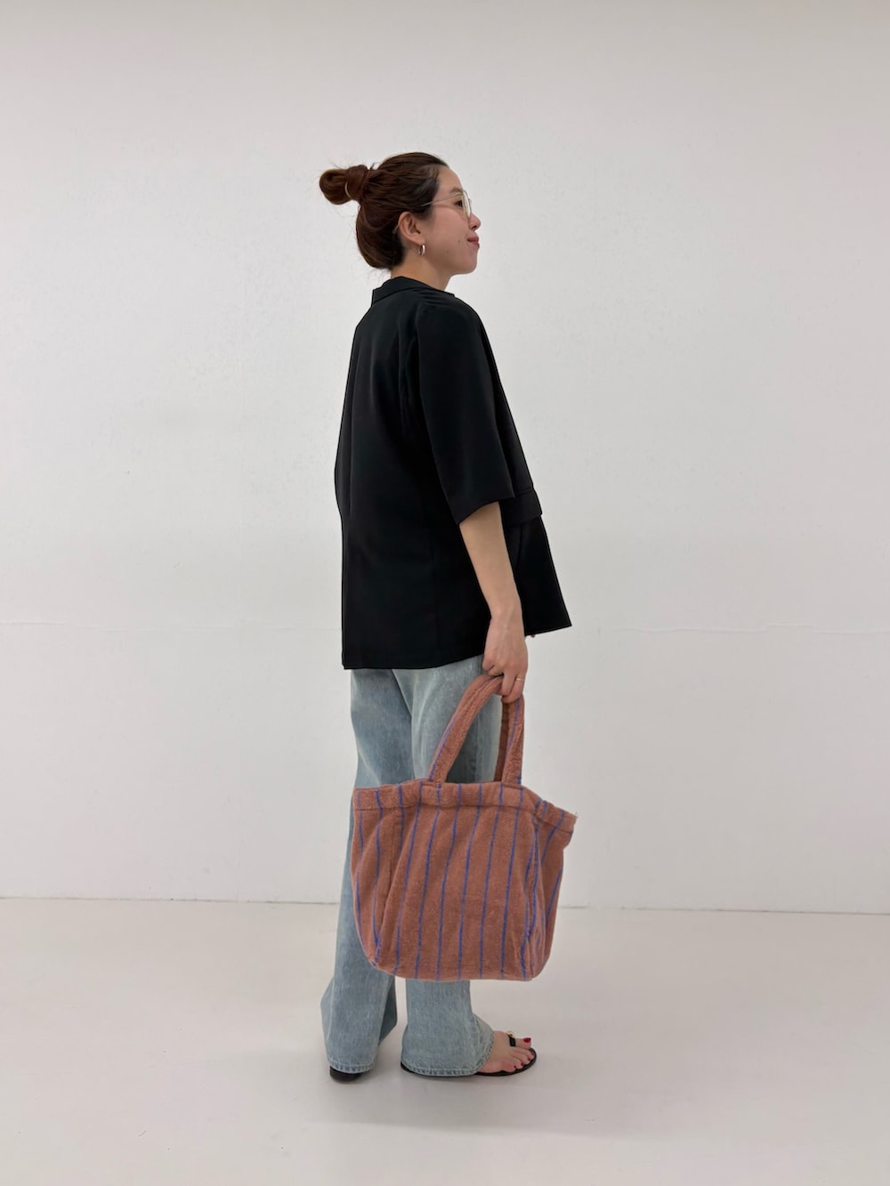 ブルー系のデニムパンツ、ホワイト系のその他トップス、イエロー系のハンドバッグを着用したレディースの春コーディネートの6枚目の写真