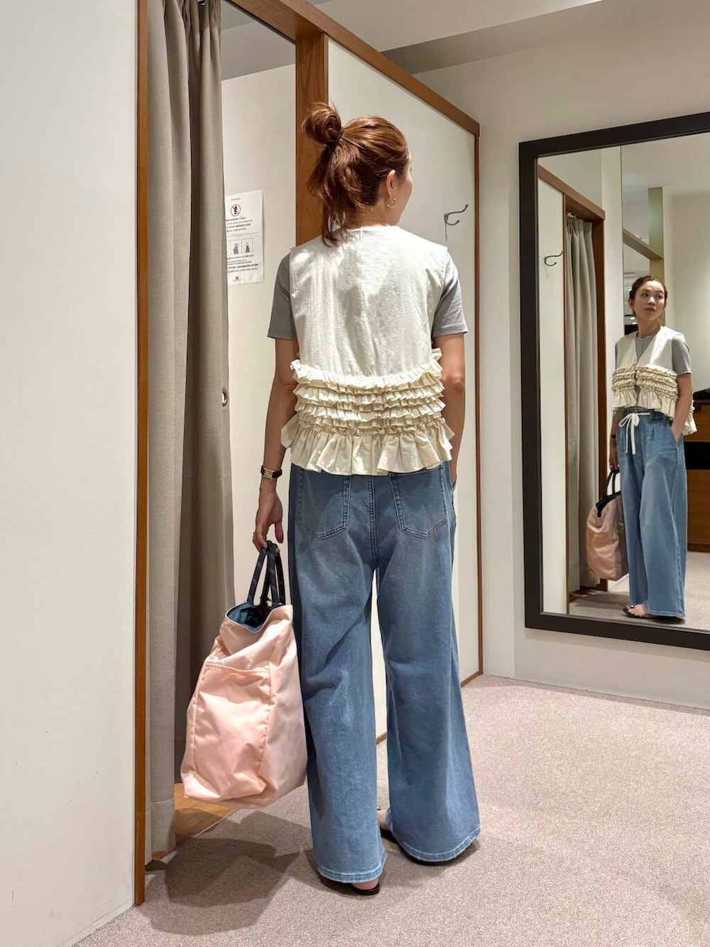 ピンク系のトートバッグ、ブルー系のデニムパンツ、ホワイト系のシャツ/ブラウスを着用したレディースの夏コーディネートの4枚目の写真