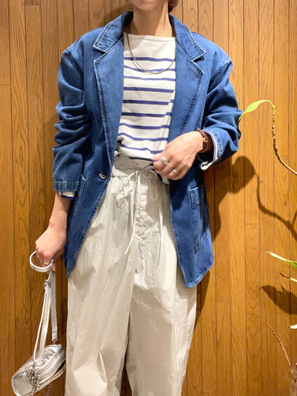 シルバー系のショルダーバッグ、ホワイト系のパンプス、ブルー系のデニムジャケットを着用したレディースの冬コーディネートの4枚目の写真