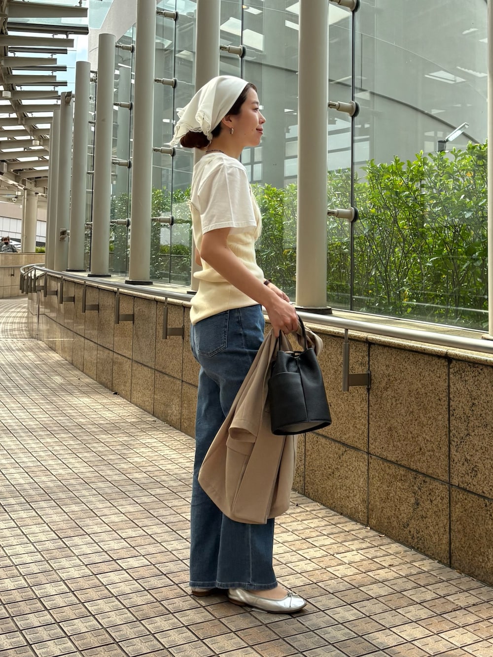 ブルー系のデニムパンツ、ベージュ系のその他アウター、ブラック系のハンドバッグを着用したレディースの春コーディネートの8枚目の写真