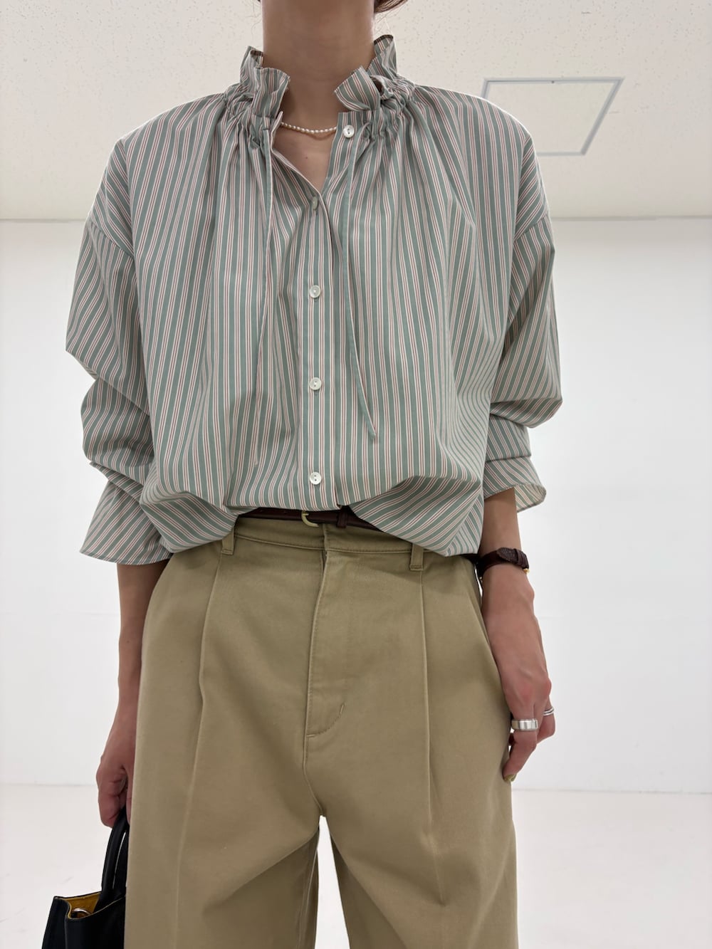 グリーン系のシャツ/ブラウス、ベージュ系のその他パンツ、ブラック系のローファーを着用したレディースの秋コーディネートの6枚目の写真