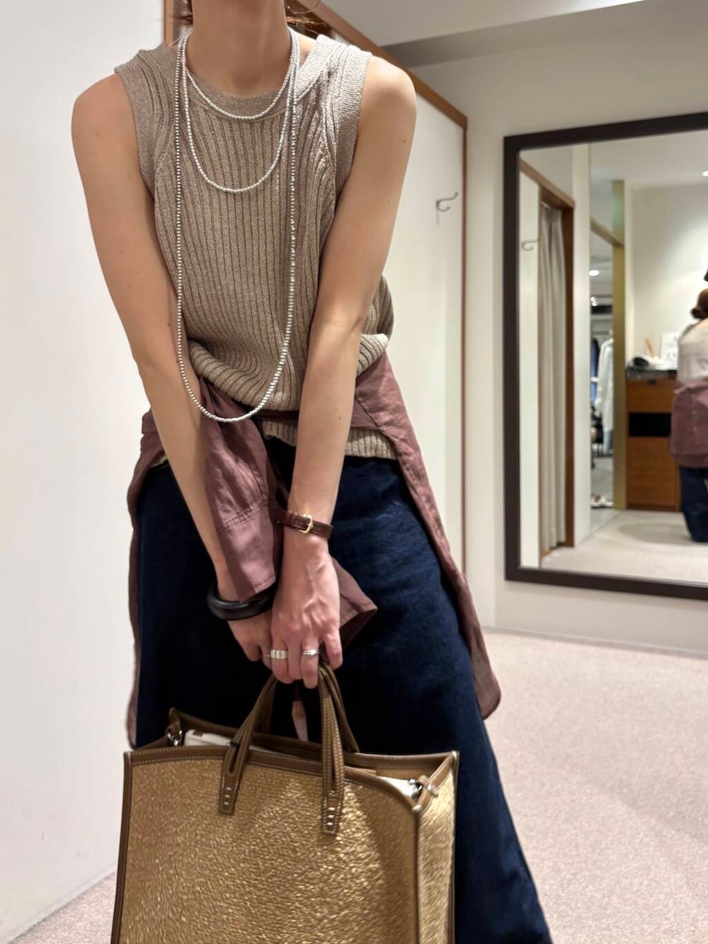 ブルー系のデニムパンツ、イエロー系のニット/セーター、ブラウン系のシャツ/ブラウスを着用したレディースの夏コーディネートの5枚目の写真