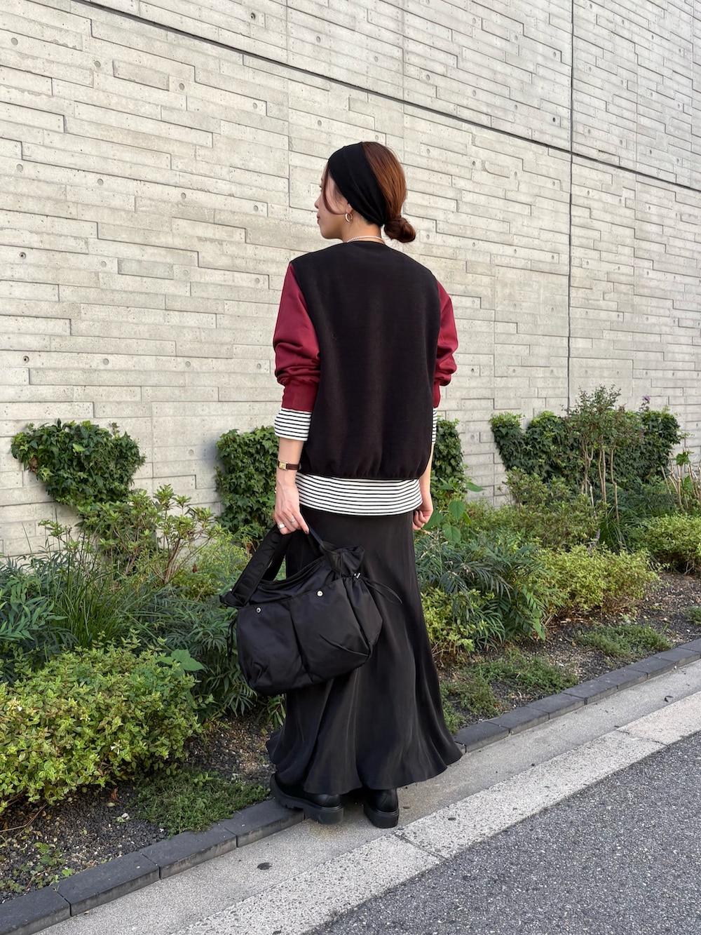 レッド系のスウェット、ブラック系のスカート、ブラック系のショルダーバッグを着用したレディースの秋コーディネートの4枚目の写真