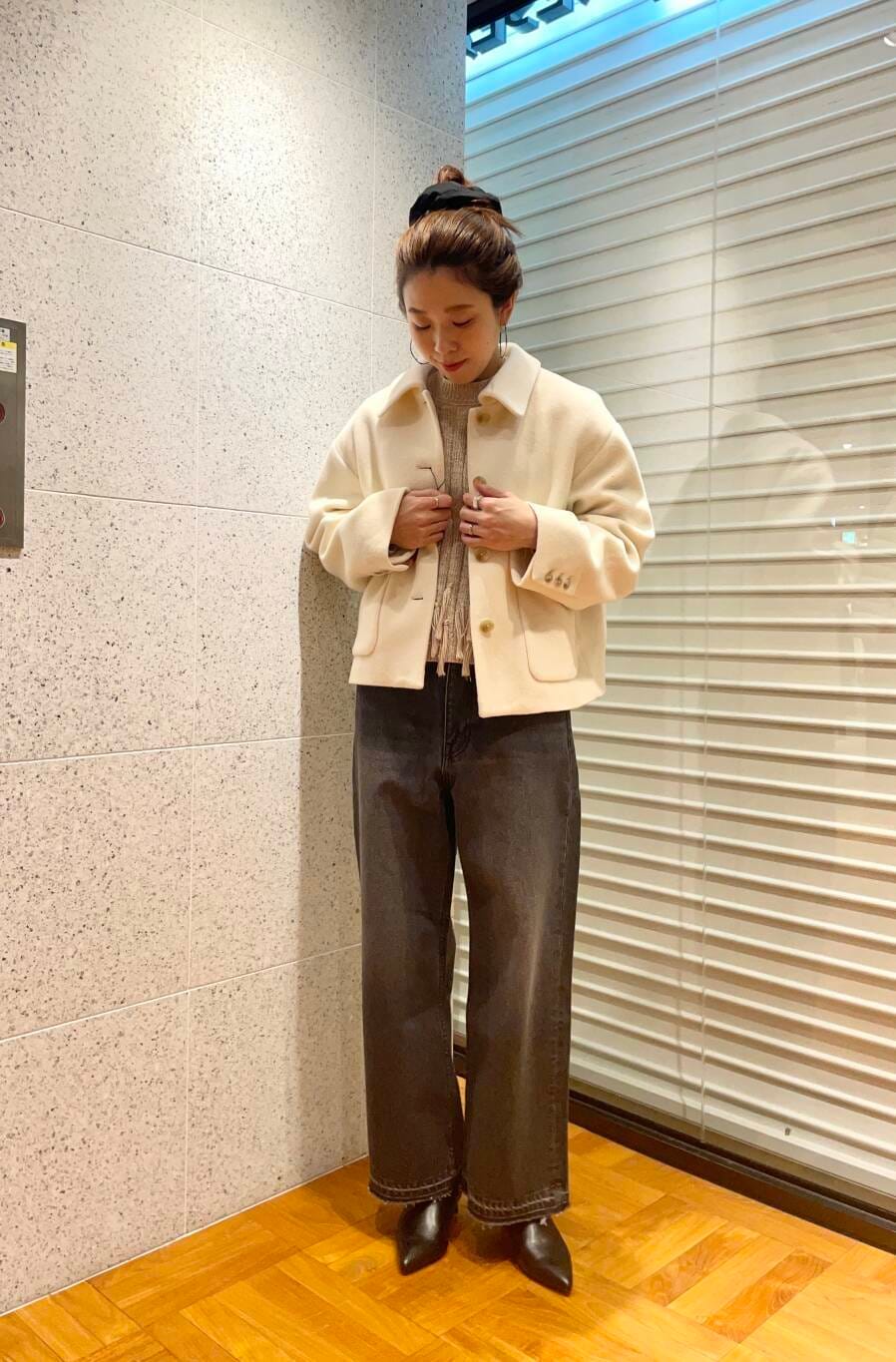 ブラック系のデニムパンツ、ブラウン系のニット/セーター、ブラック系のブーツを着用したレディースの冬コーディネートの2枚目の写真