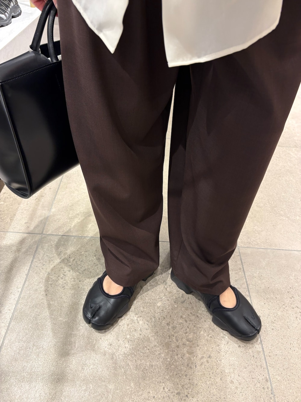 ブラウン系のその他パンツ、ブラック系のスニーカー、ブラック系のハンドバッグを着用したレディースの春コーディネートの8枚目の写真