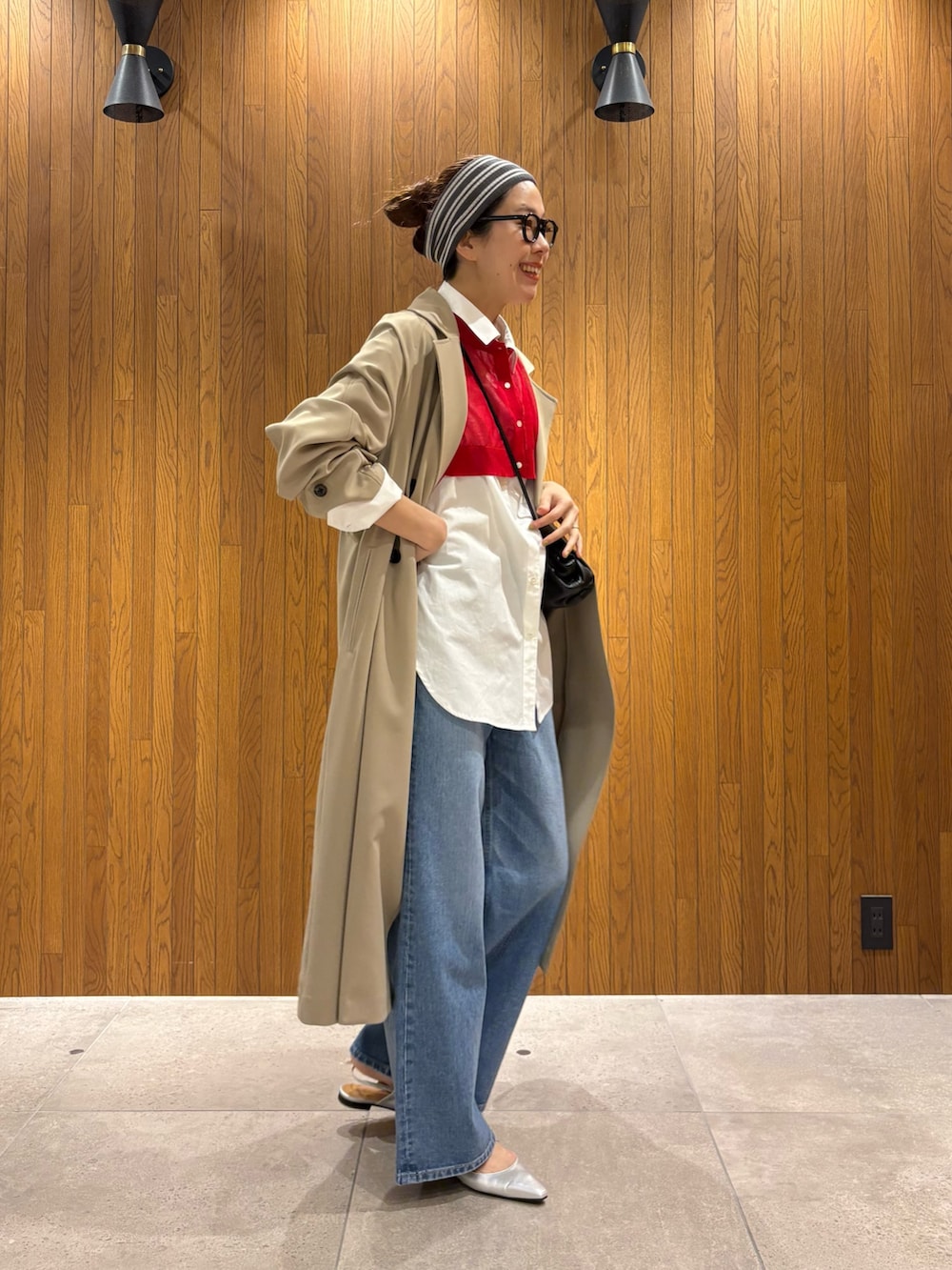 ベージュ系のトレンチコート、ブルー系のデニムパンツ、シルバー系のパンプスを着用したレディースの春コーディネートの5枚目の写真