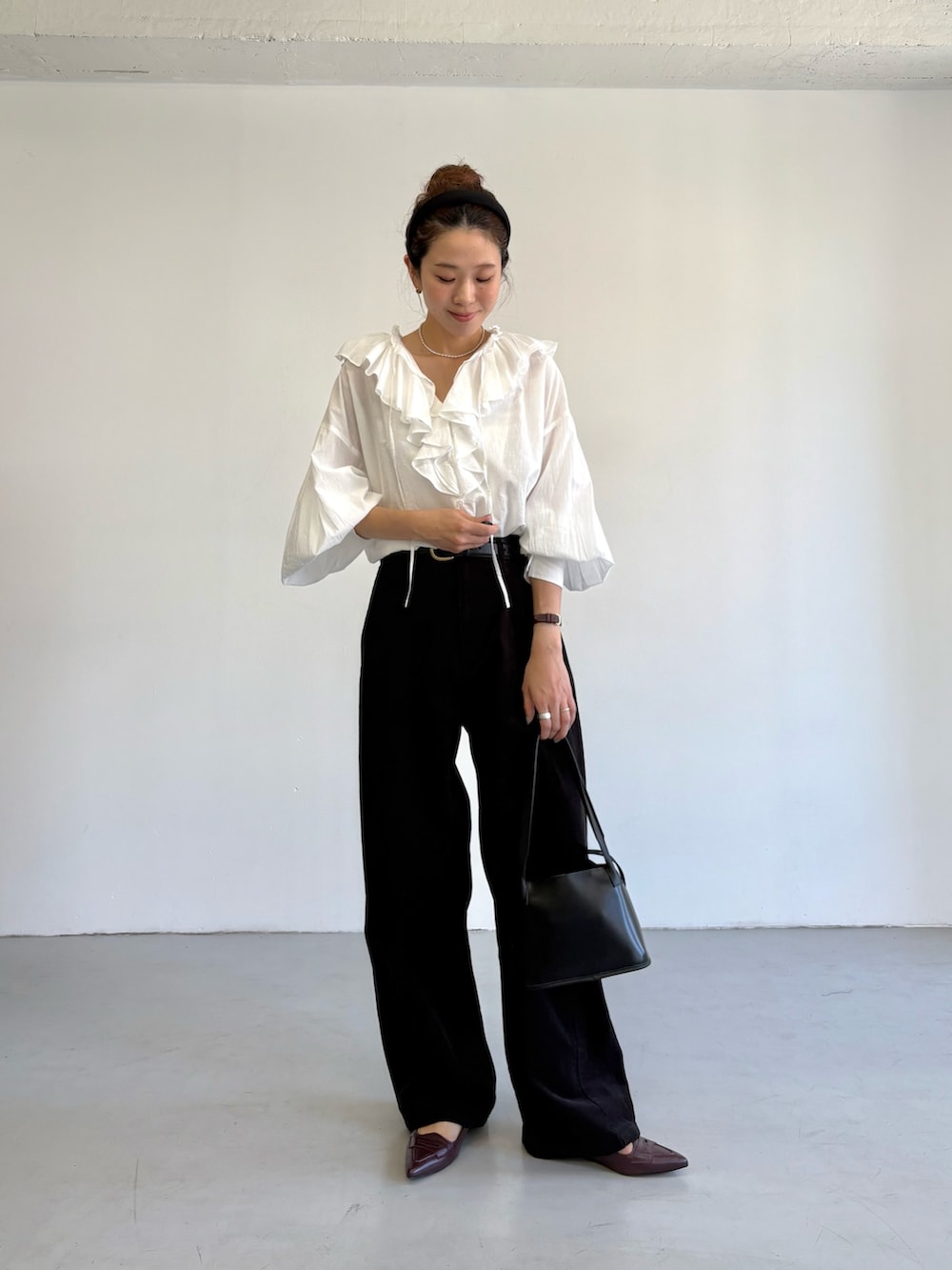 グレー系のその他パンツ、ホワイト系のシャツ/ブラウス、ブラック系のハンドバッグを着用したレディースの秋コーディネートの6枚目の写真