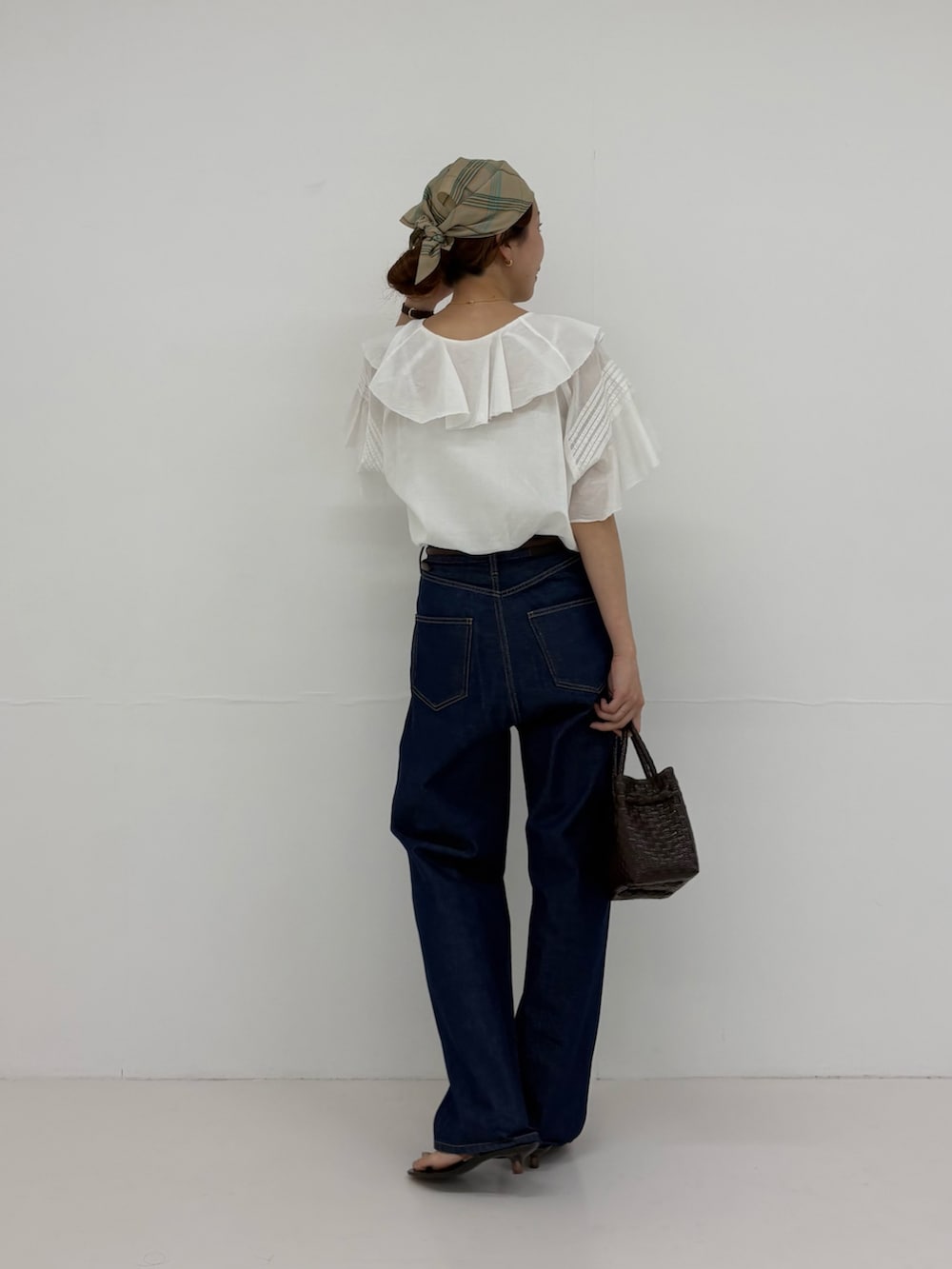 ホワイト系のシャツ/ブラウス、ブルー系のデニムパンツ、ブラウン系のトートバッグを着用したレディースの夏コーディネートの4枚目の写真