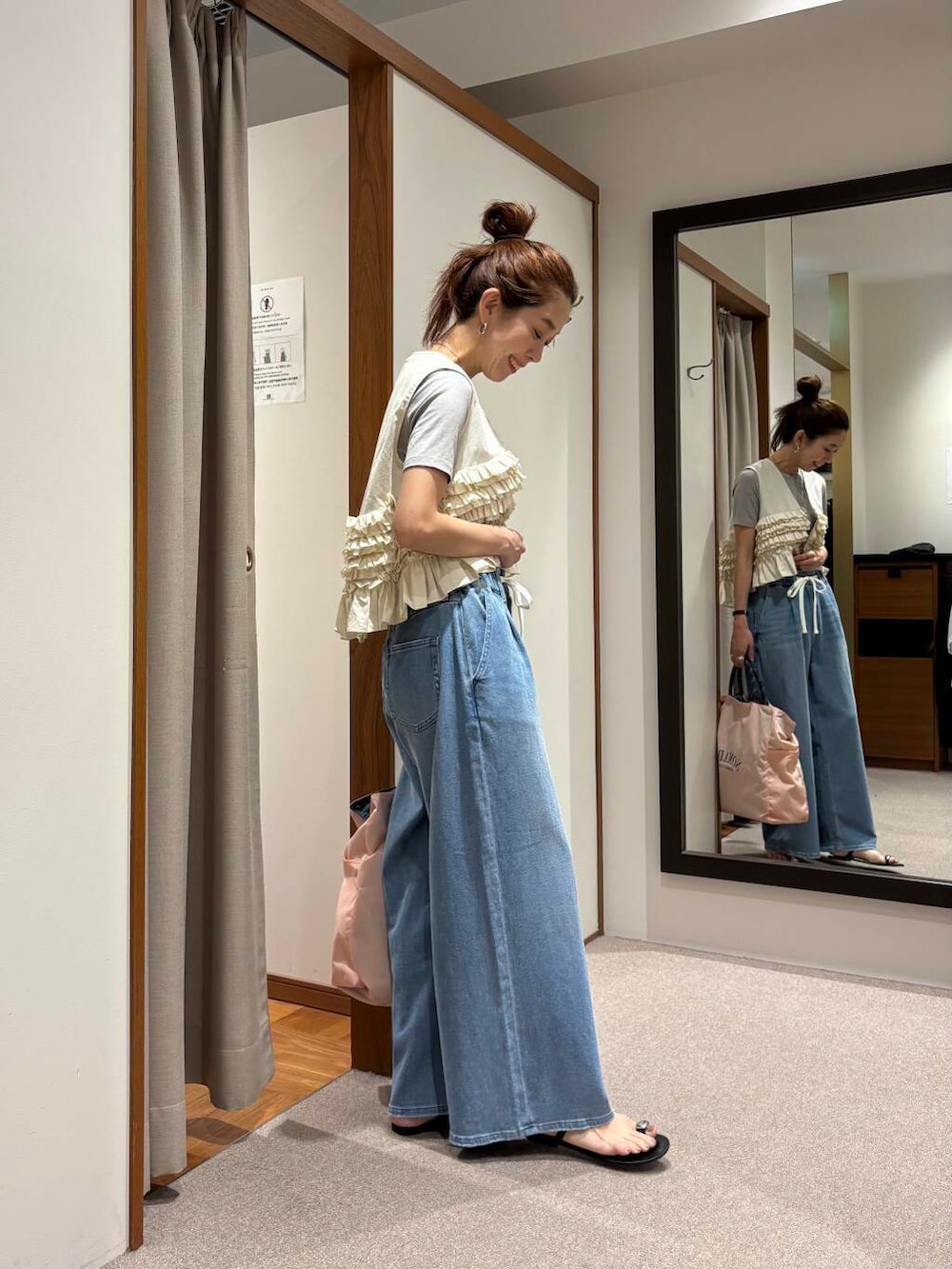 ピンク系のトートバッグ、ブルー系のデニムパンツ、ホワイト系のシャツ/ブラウスを着用したレディースの夏コーディネートの2枚目の写真