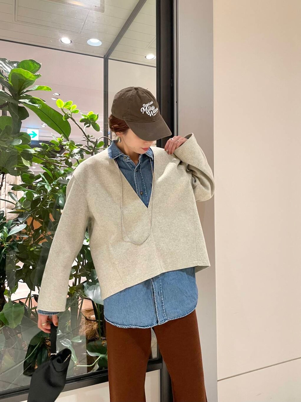 ブラック系のダウンジャケット/コート、ブラウン系のその他パンツ、ホワイト系のTシャツ/カットソーを着用したレディースの冬コーディネートの5枚目の写真