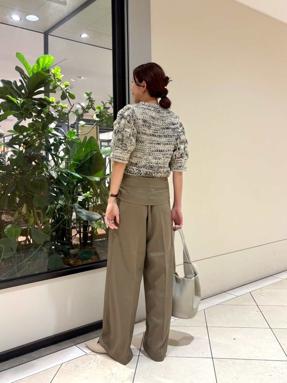 ホワイト系のニット/セーター、ブラウン系のその他パンツ、ホワイト系のハンドバッグを着用したレディースの秋コーディネートの3枚目の写真