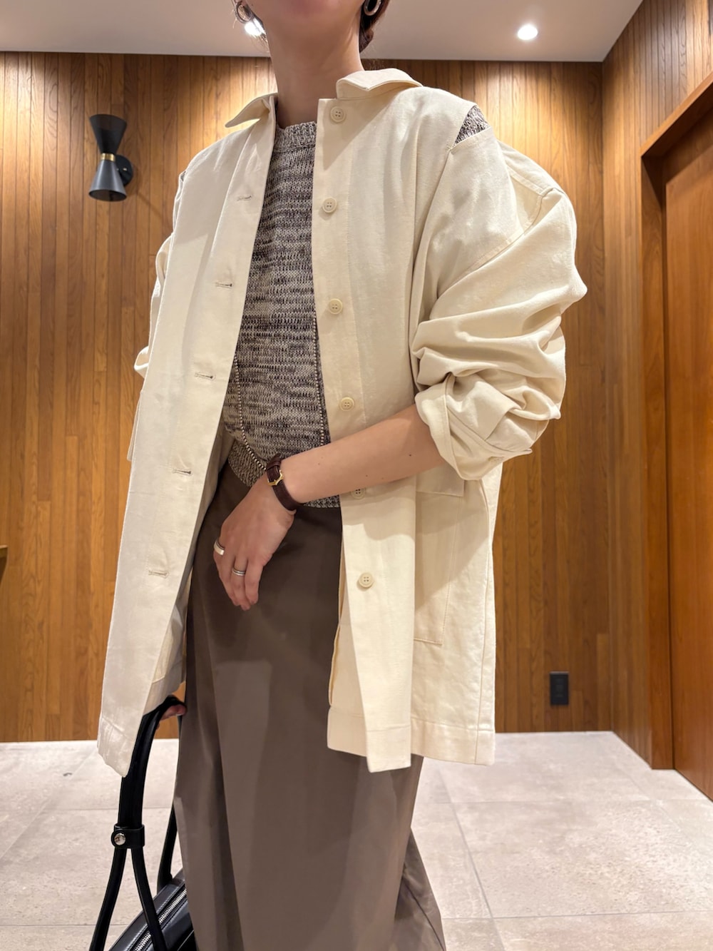 グレー系のスカート、その他のニット/セーター、ブラック系のスニーカーを着用したレディースの春コーディネートの5枚目の写真