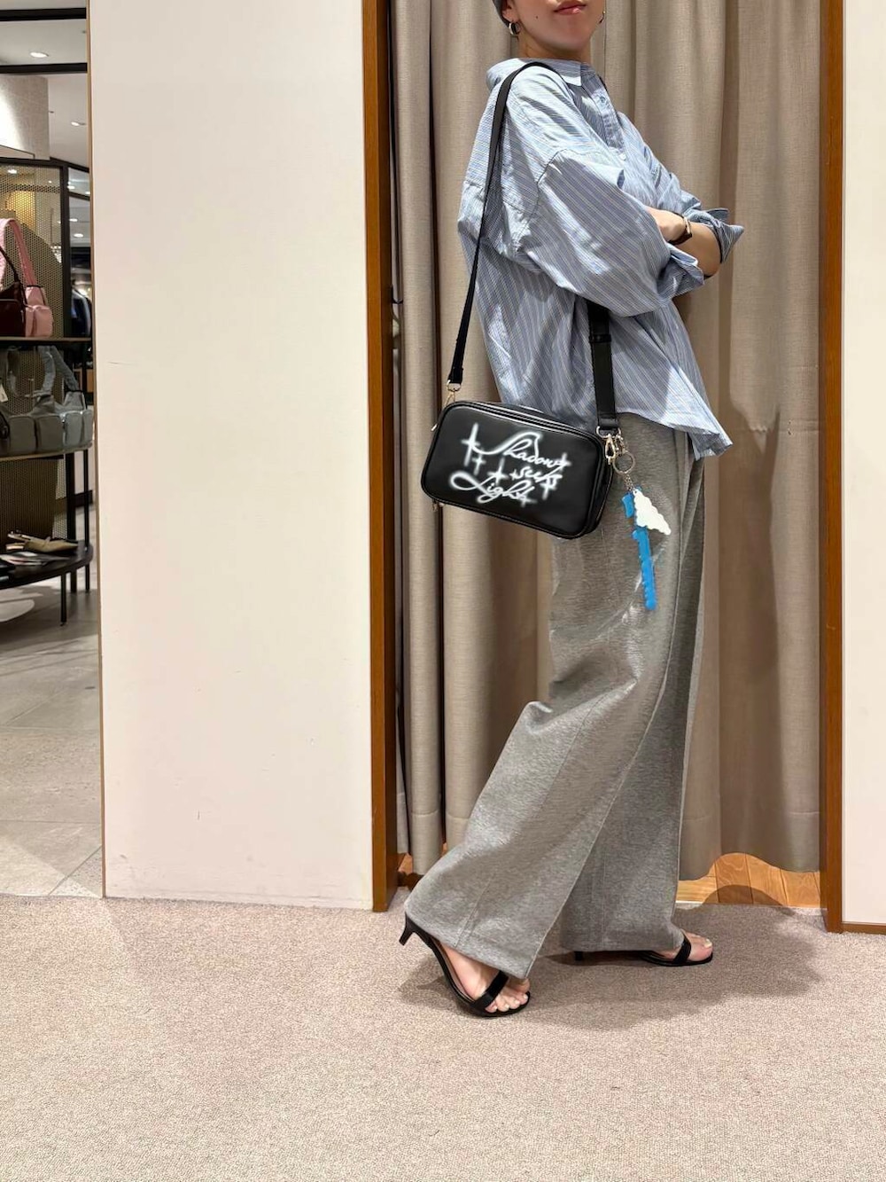 ブルー系のシャツ/ブラウス、ブラック系のショルダーバッグ、グレー系のその他パンツを着用したレディースの春コーディネートの3枚目の写真