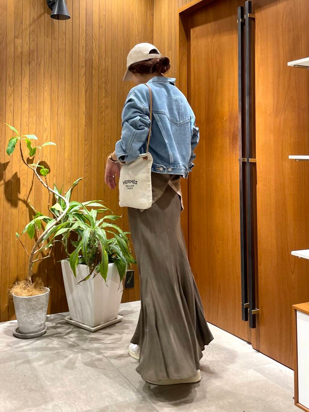 グリーン系のスカート、ブルー系のデニムジャケット、ホワイト系のスニーカーを着用したレディースの秋コーディネートの5枚目の写真