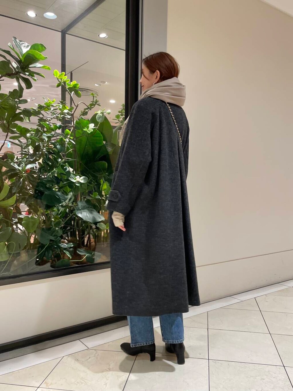 ブルー系のデニムパンツ、ブラック系のショルダーバッグ、レッド系のニット/セーターを着用したレディースの冬コーディネートの6枚目の写真