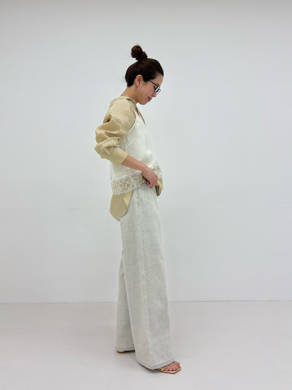 ホワイト系のキャミソール、グレー系のデニムパンツ、ベージュ系のシャツ/ブラウスを着用したレディースの冬コーディネートの4枚目の写真