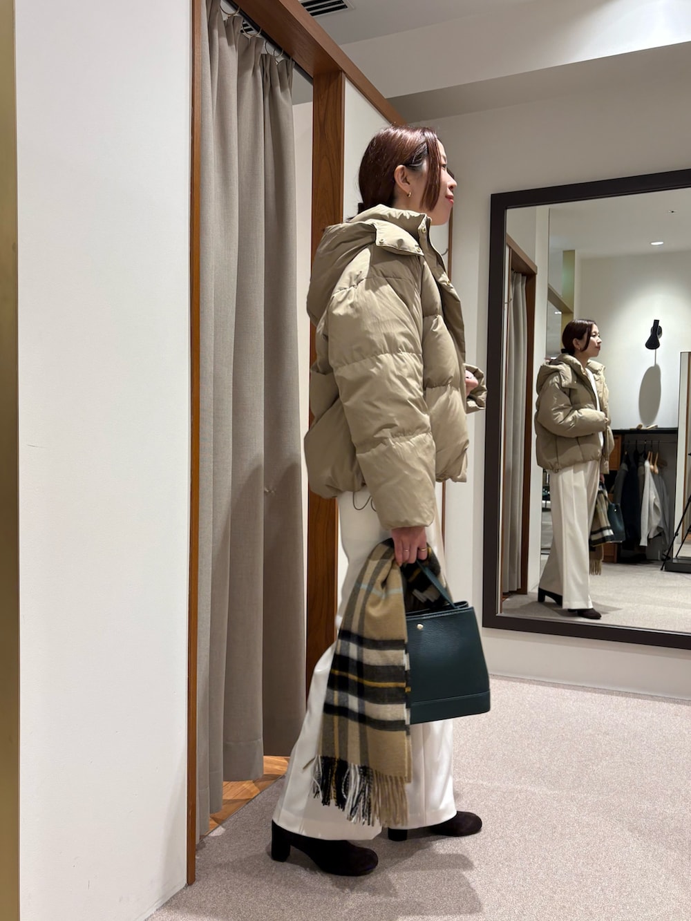 ベージュ系のダウンジャケット/コート、グリーン系のニット/セーター、ホワイト系のその他パンツを着用したレディースの秋コーディネートの3枚目の写真