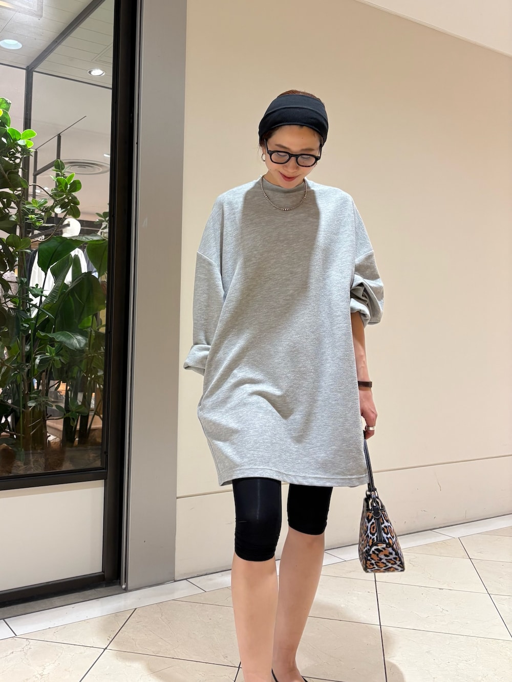 パープル系のハンドバッグ、ブラック系のパンプス、グレー系のワンピースを着用したレディースの春コーディネートの5枚目の写真