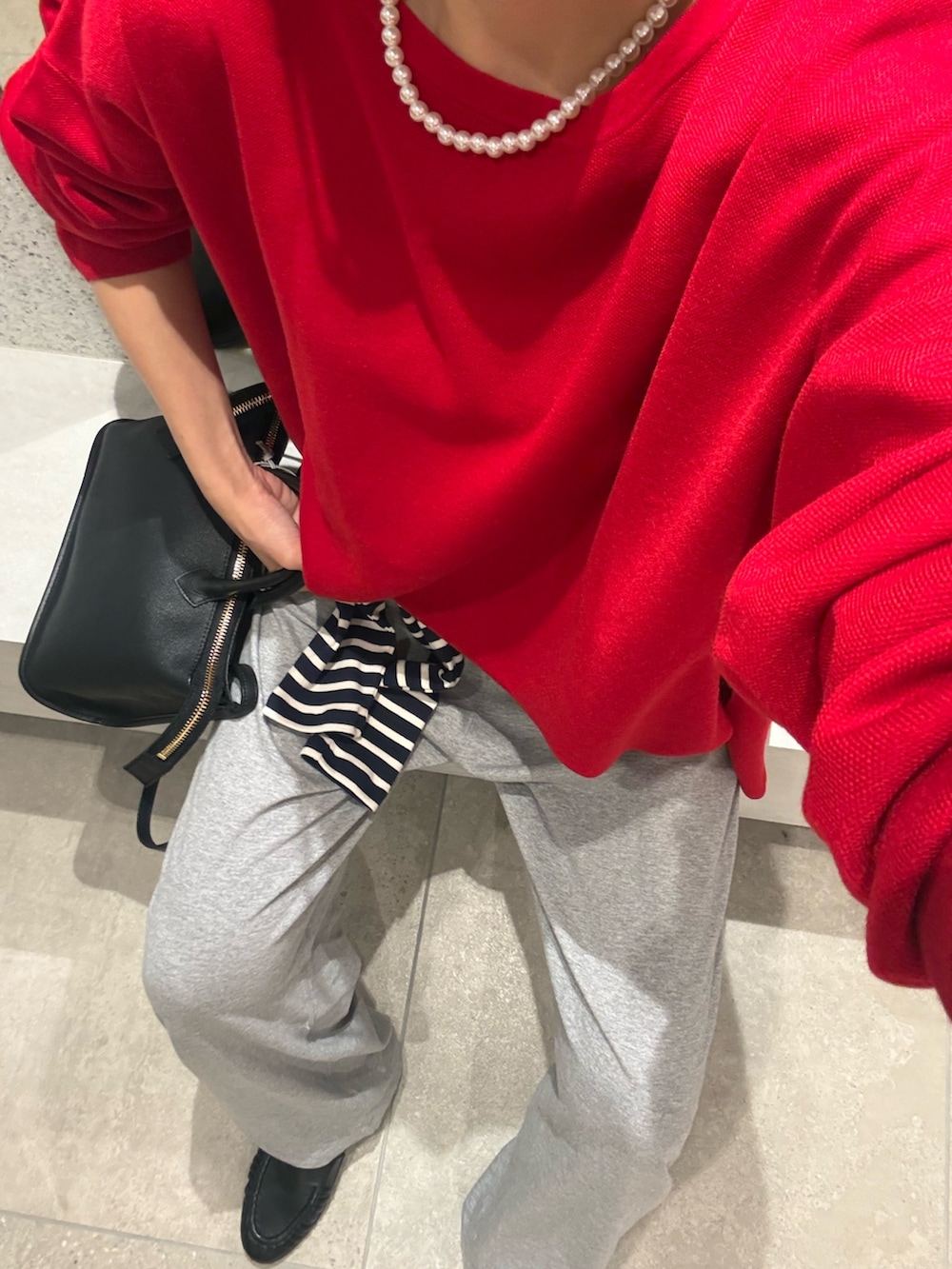 レッド系のニット/セーター、ブルー系のTシャツ/カットソー、グレー系のその他パンツを着用したレディースの秋コーディネートの9枚目の写真