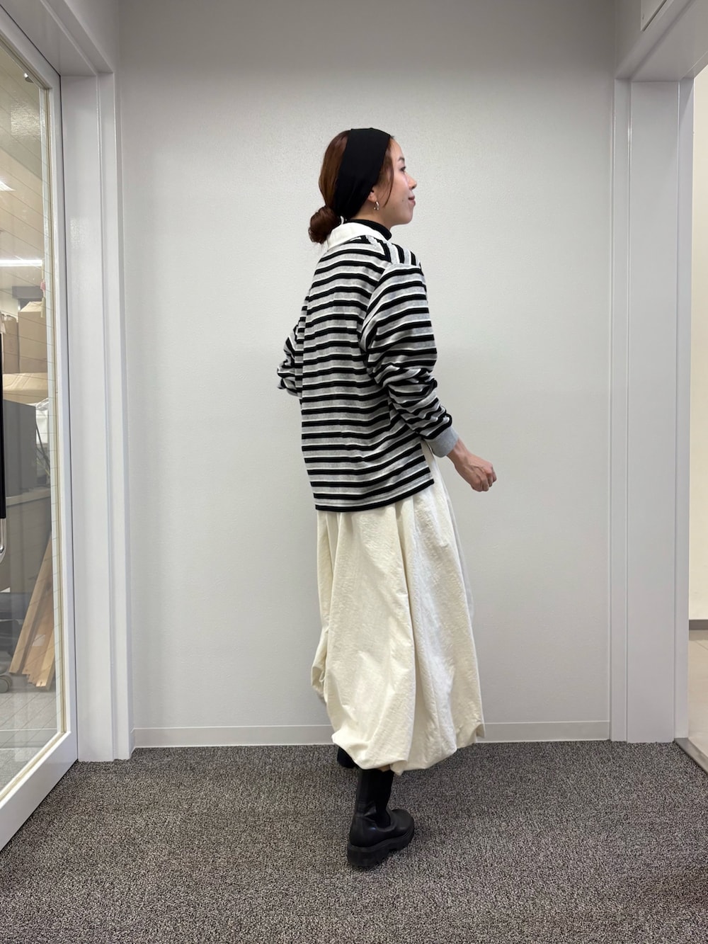 ホワイト系のスカート、ブラック系のニット/セーター、レッド系のTシャツ/カットソーを着用したレディースの秋コーディネートの5枚目の写真