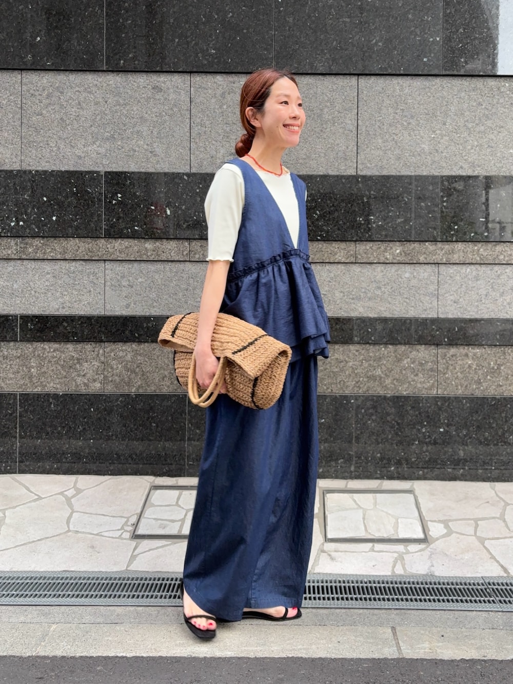 ブルー系のサロペット/オーバーオール、ベージュ系のトートバッグ、ホワイト系のTシャツ/カットソーを着用したレディースの春コーディネートの4枚目の写真