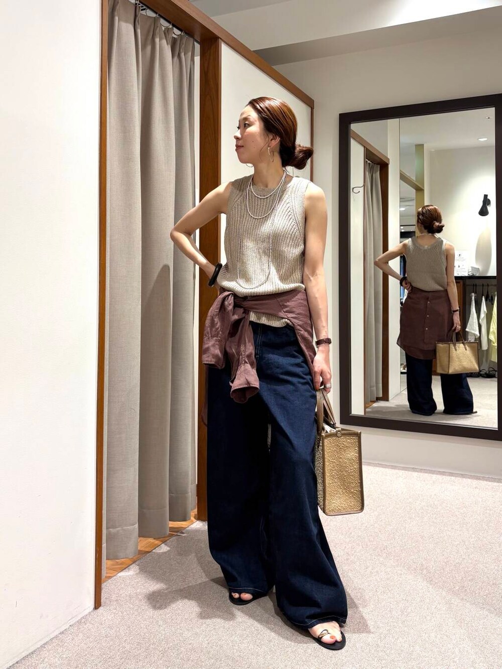 ブルー系のデニムパンツ、イエロー系のニット/セーター、ブラウン系のシャツ/ブラウスを着用したレディースの夏コーディネートの4枚目の写真