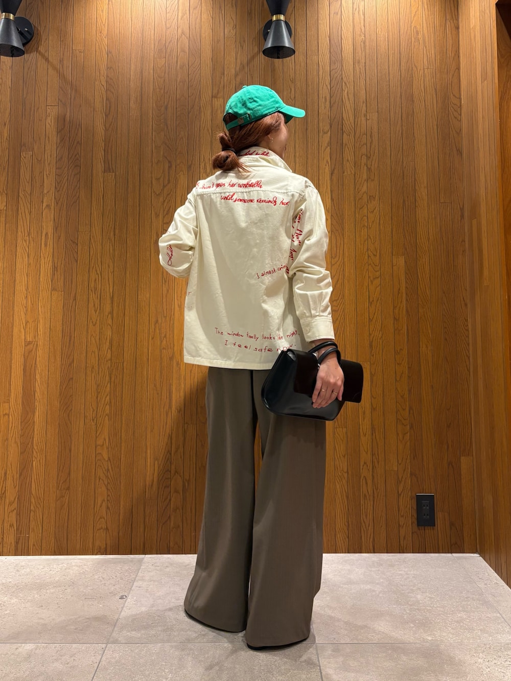 ブラック系のハンドバッグ、シルバー系のサンダル、ホワイト系のTシャツ/カットソーを着用したレディースの秋コーディネートの3枚目の写真