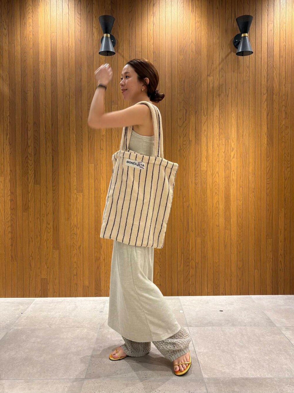 ゴールド系のサンダルを着用したレディースの夏コーディネートの6枚目の写真