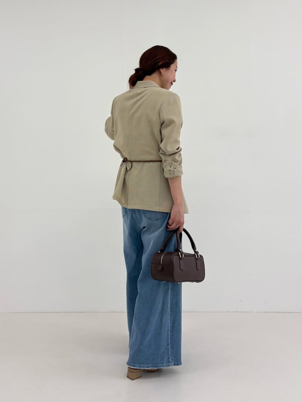 ベージュ系のその他アウター、イエロー系のTシャツ/カットソー、ブルー系のデニムパンツを着用したレディースの春コーディネートの4枚目の写真